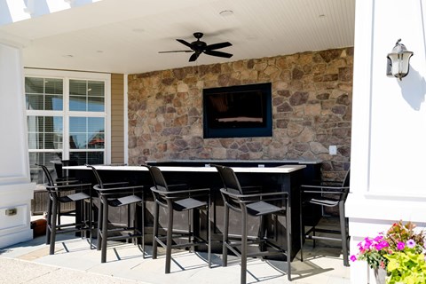 A patio with a table and chairs and a stone wall.