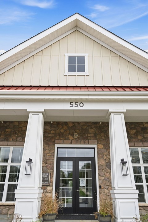 The clubhouse with white pillars, red roof, and black doors