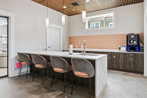 A kitchen with a white counter and chairs.