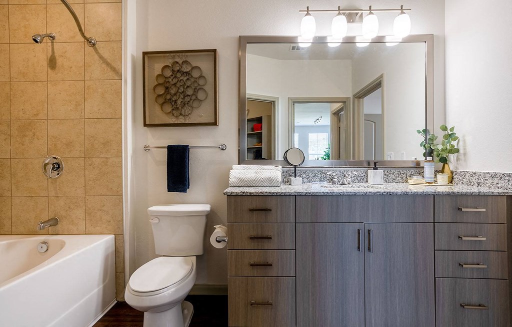 a bathroom with a sink toilet and a mirror at The Parkway on Westlake, Texas, 77346
