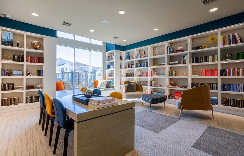 a library with bookshelves and a table and chairs  at The Parkway on Westlake, Humble, 77346