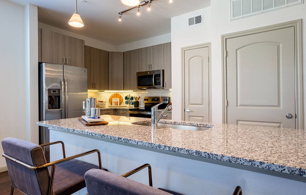 a kitchen with a counter top and a stainless steel refrigerator at The Parkway on Westlake, Humble, Texas