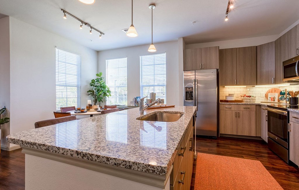 a kitchen with a granite counter top and a sink at The Parkway on Westlake, Humble, TX