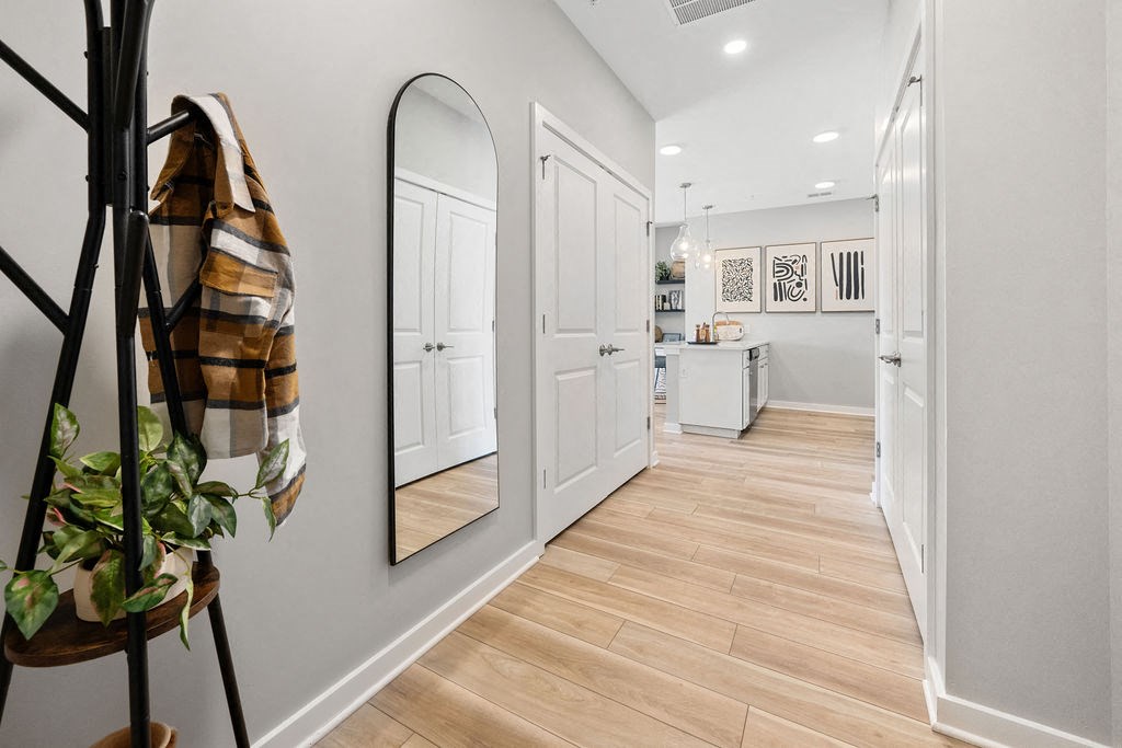 A hallway with a coat rack and mirrors on the wall