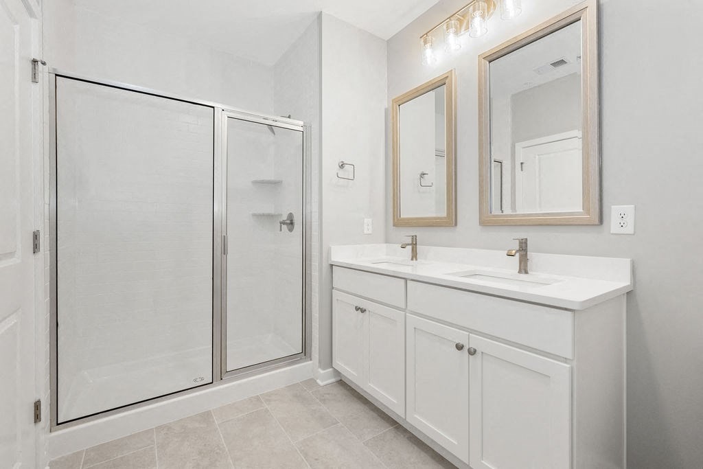 A white bathroom with a walk-in shower and double sink vanity at Madison Prickett Preserve, Pennsylvania