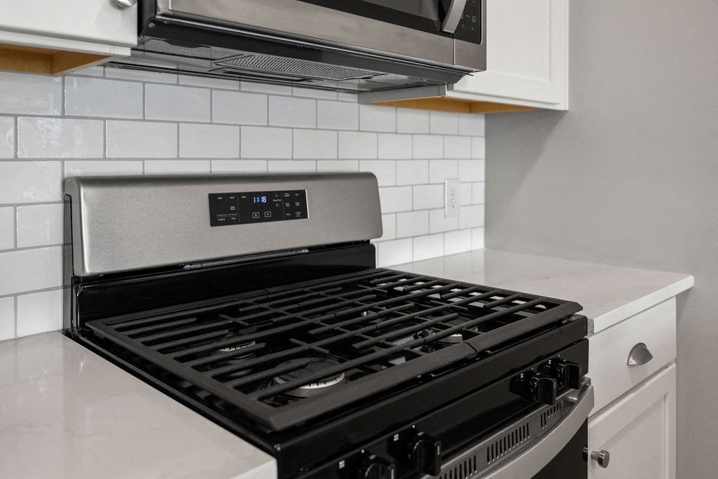 A modern kitchen with a stove top oven and microwave above it at Madison Prickett Preserve, Yardley, 19067