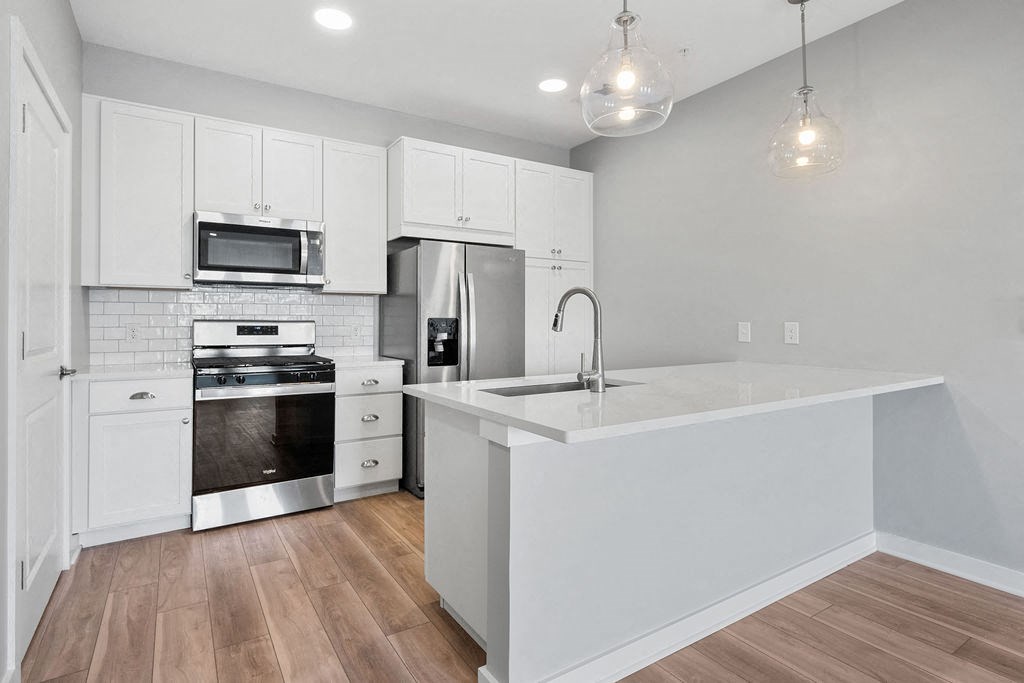 A modern kitchen with white cabinets and stainless steel appliances at Madison Prickett Preserve, Yardley