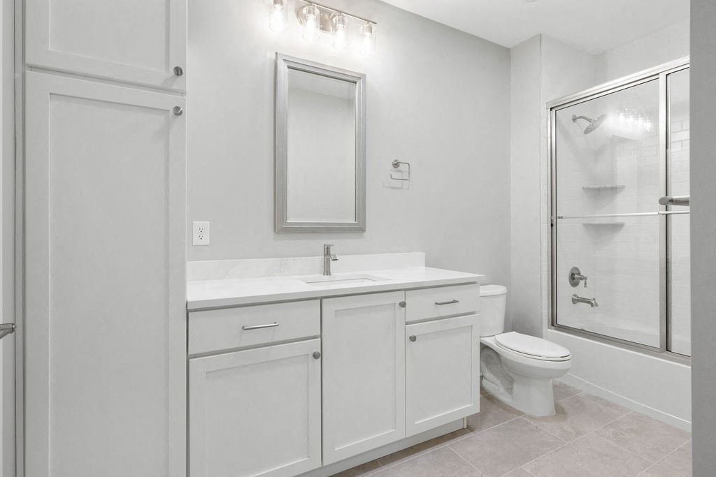 A white bathroom with a toilet, sink, and mirror at Madison Prickett Preserve, Pennsylvania, 19067