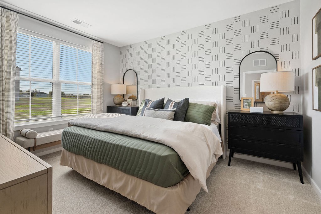 A bedroom with a large bed, a nightstand, and a window with blinds at Madison Prickett Preserve, Yardley Pennsylvania