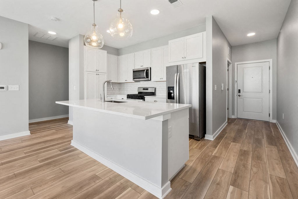 A kitchen with a white island and wooden floors at Madison Prickett Preserve, Yardley Pennsylvania