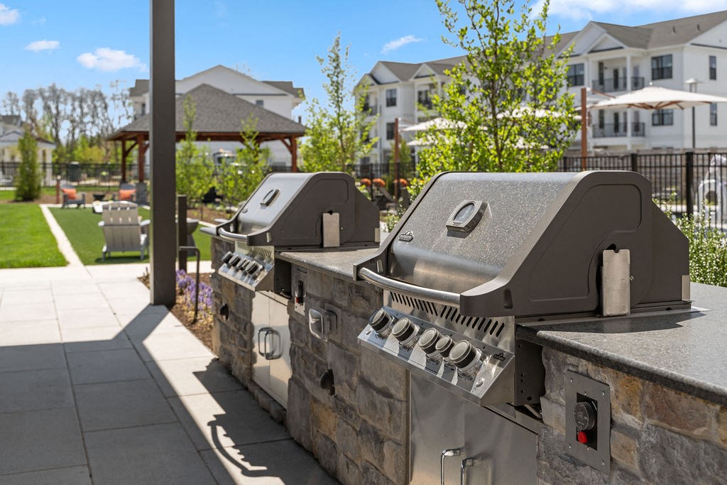 two bbq grills on a stone wall in front of a building at Madison Prickett Preserve, Yardley
