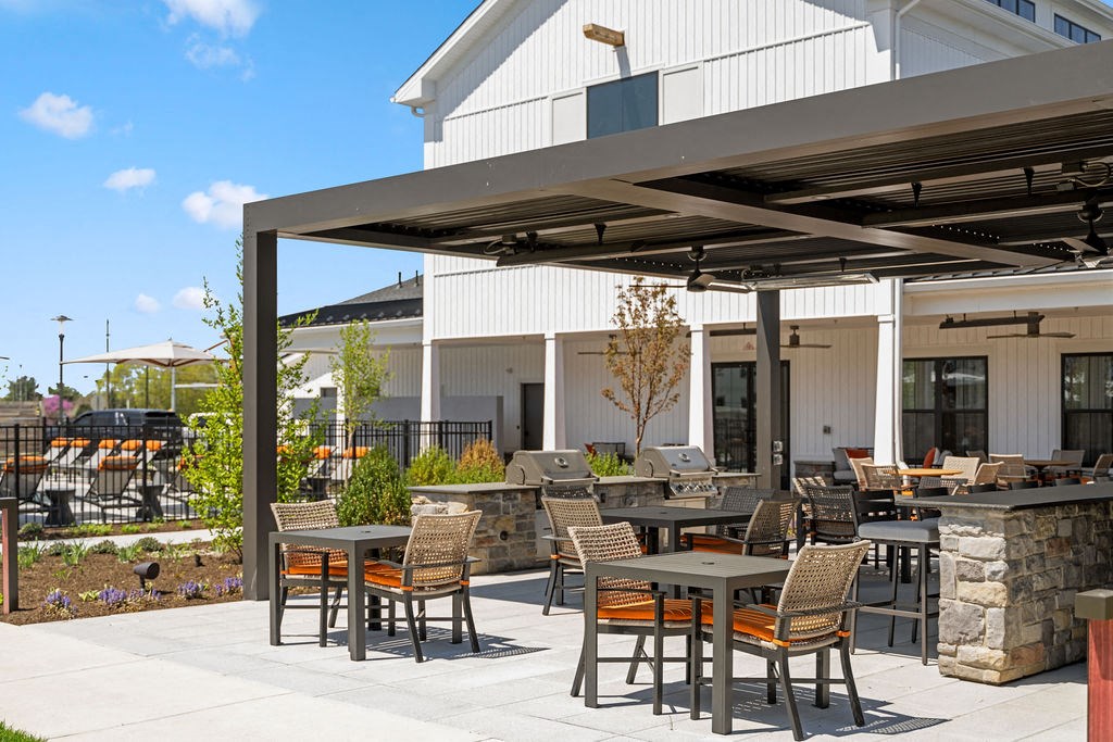 A patio with a table and chairs is shaded by a large awning at Madison Prickett Preserve, Yardley