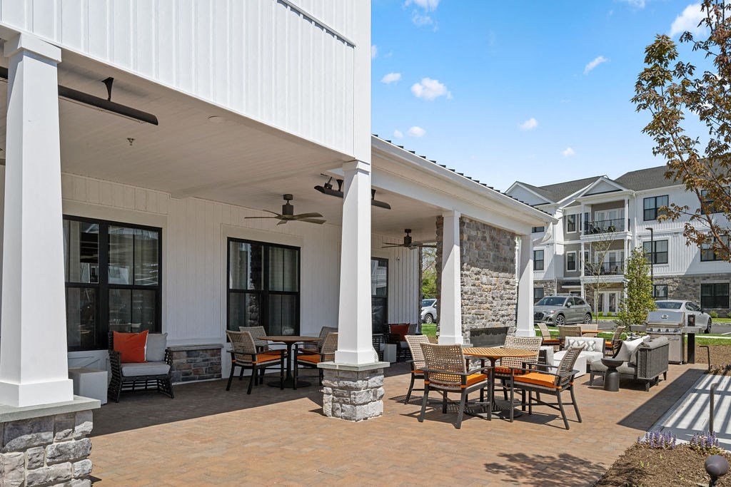 A patio with a table and chairs is in front of a white building at Madison Prickett Preserve, Yardley Pennsylvania