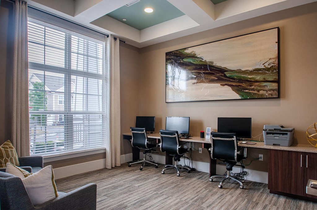 a workspace with computers and a large painting on the wall  at Madison Providence, Collegeville, PA