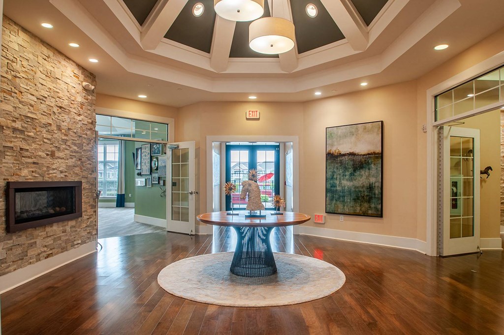 a round table with a vase of flowers in the center of a room with a fireplace  at Madison Providence, Pennsylvania, 19426