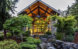 a home in the woods with a stone and wood exterior at Madison Sierra Sun, Puyallup, 98374