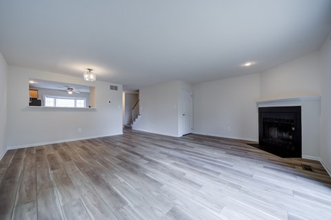 A spacious living room with a fireplace and hardwood floors.