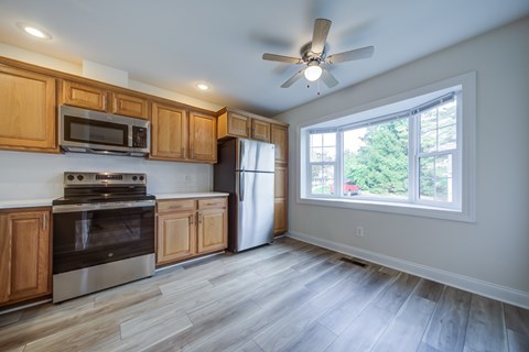 A kitchen with wooden cabinets and a stainless steel oven.