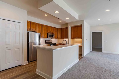 A kitchen with wooden cabinets and a white island.