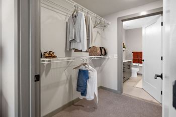 A white closet with clothes hanging and a shelf with a bag on it at Madison West Elm, Conshohocken, PA 19428