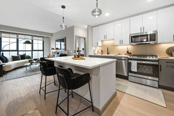 an open kitchen and living room with a white counter top at Madison West Elm, Pennsylvania