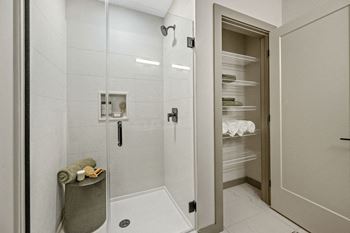 A bathroom with a walk-in shower and a large open door leading to a pantry at Madison West Elm, Conshohocken, PA 19428