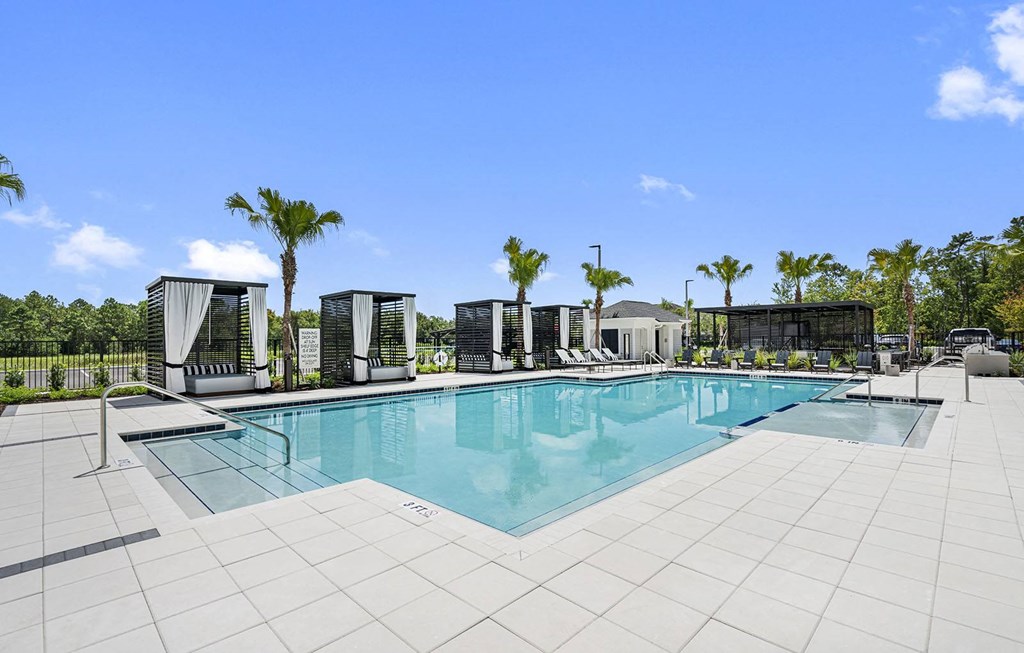 a swimming pool at a resort with palm trees at Madison Waterford Lakes, Florida, 32826