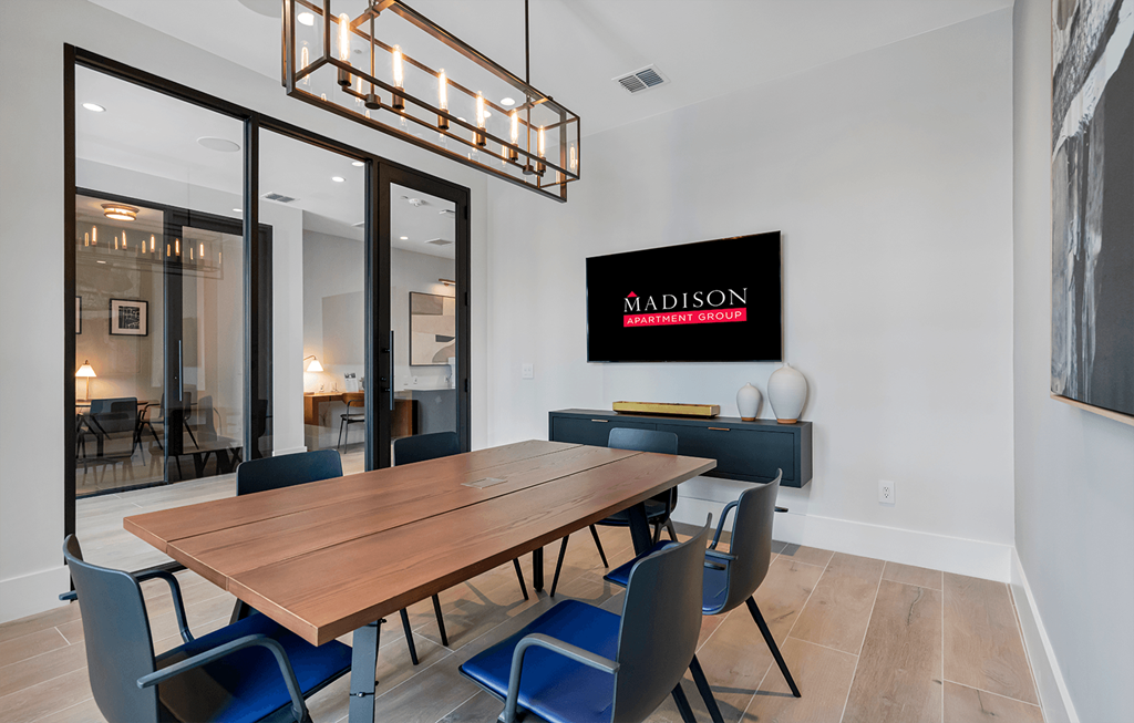 a dining room with a wooden table and blue chairs at Madison Waterford Lakes, Orlando, FL