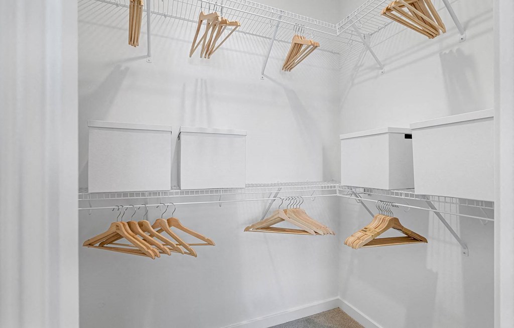 a walk in closet with wooden clothes drying racks at Madison Waterford Lakes, Orlando, FL