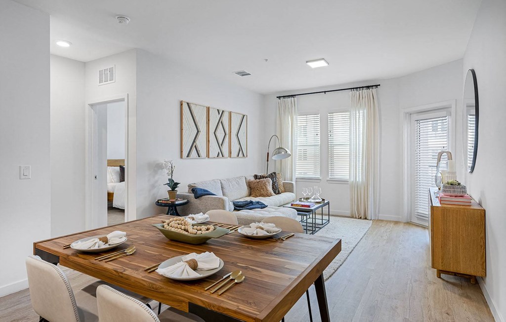 a living room and dining room with a wooden table at Madison Waterford Lakes, Orlando, FL, 32826