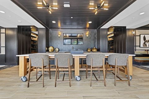 a kitchen with a long island with a bunch of chairs around it
