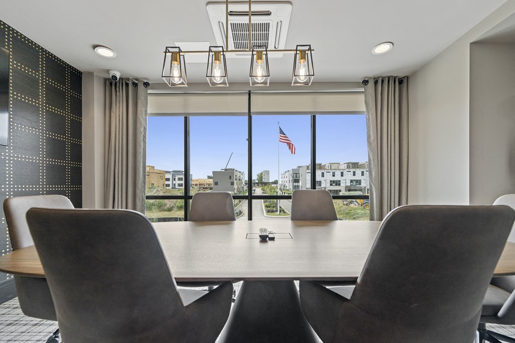 a meeting room with a table and chairs and a large window with an american flag at The Harrison, Newtown Square, PA