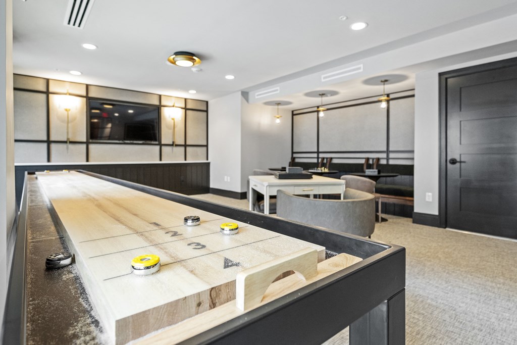 a game room with a shuffleboard table and couches at The Harrison, Newtown Square, 19073