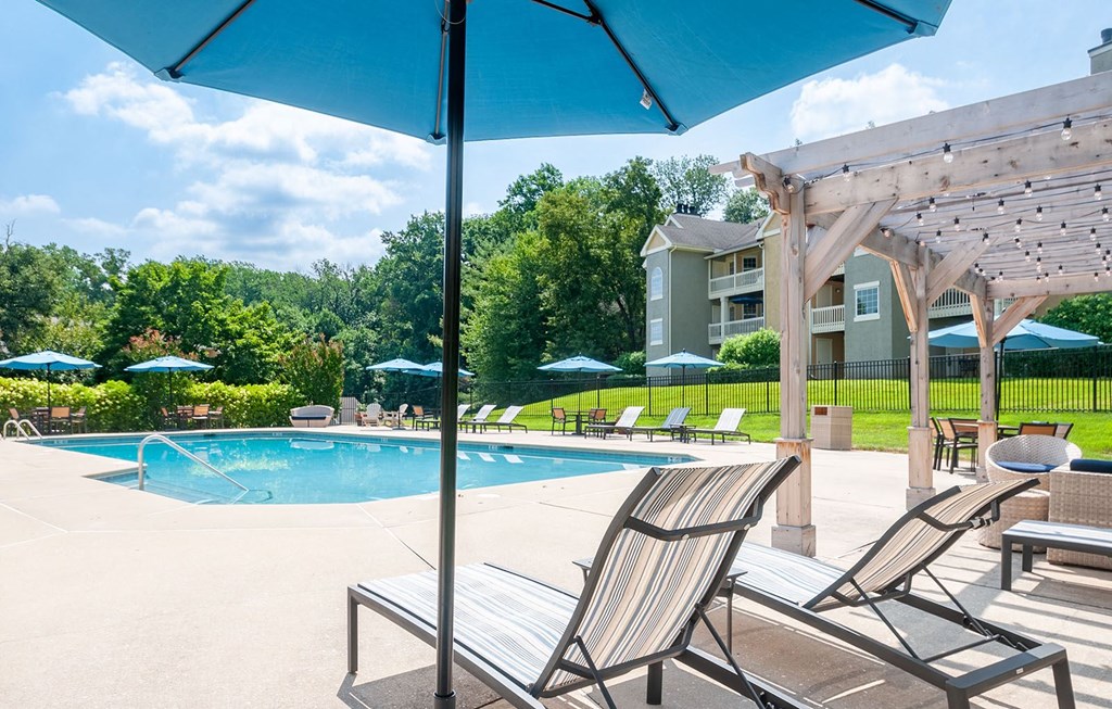 lounge chairs under umbrellas at the pool at Madison Glen Mills, Pennsylvania