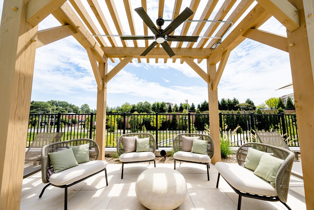 a wooden pergola with chairs and a table under it at The Harrison, Newtown Square, 19073