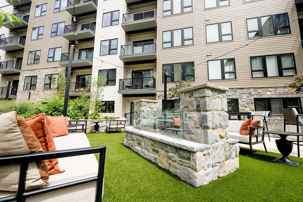 an outdoor seating area with a fireplace at the bradley braddock road station apartments at The Harrison, Newtown Square, PA, 19073
