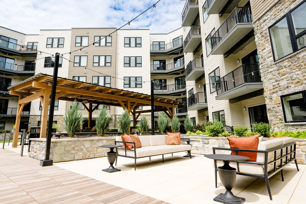 an outdoor patio with couches and tables at the flats at big tex apartments in san an at The Harrison, Pennsylvania, 19073