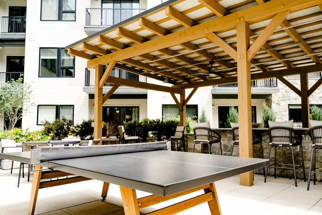 a patio with a ping pong table and a pergola at The Harrison, Pennsylvania