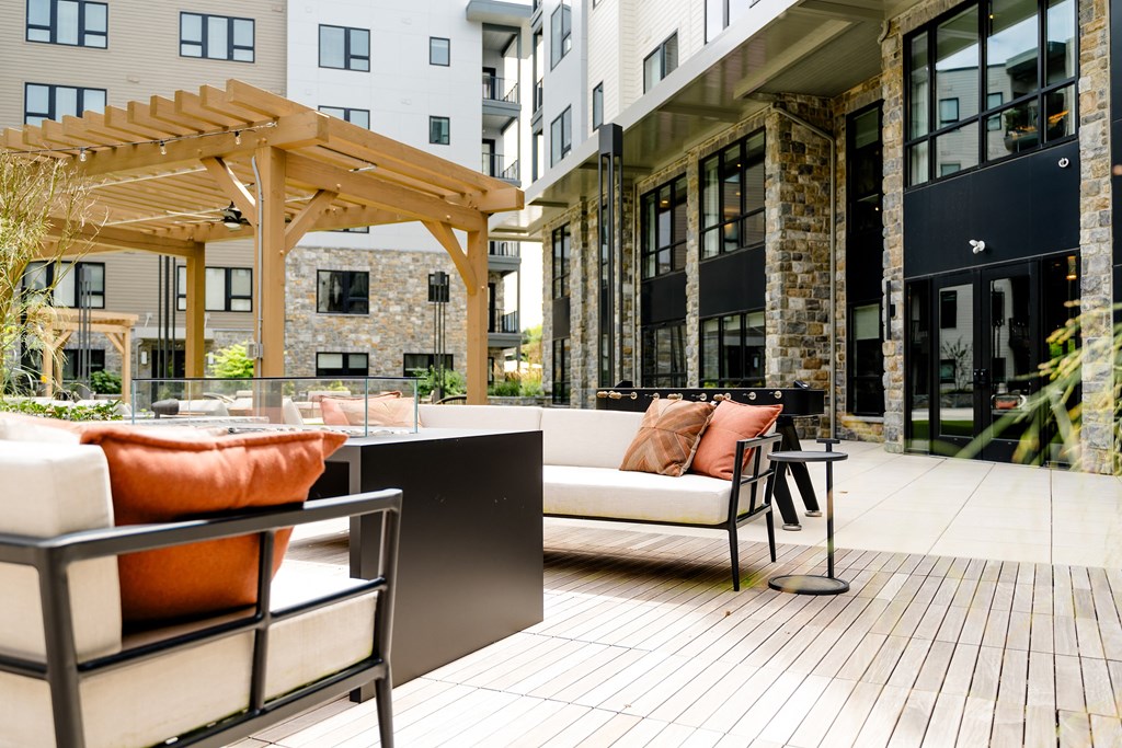 a patio with a white couch and orange pillows at The Harrison, Newtown Square