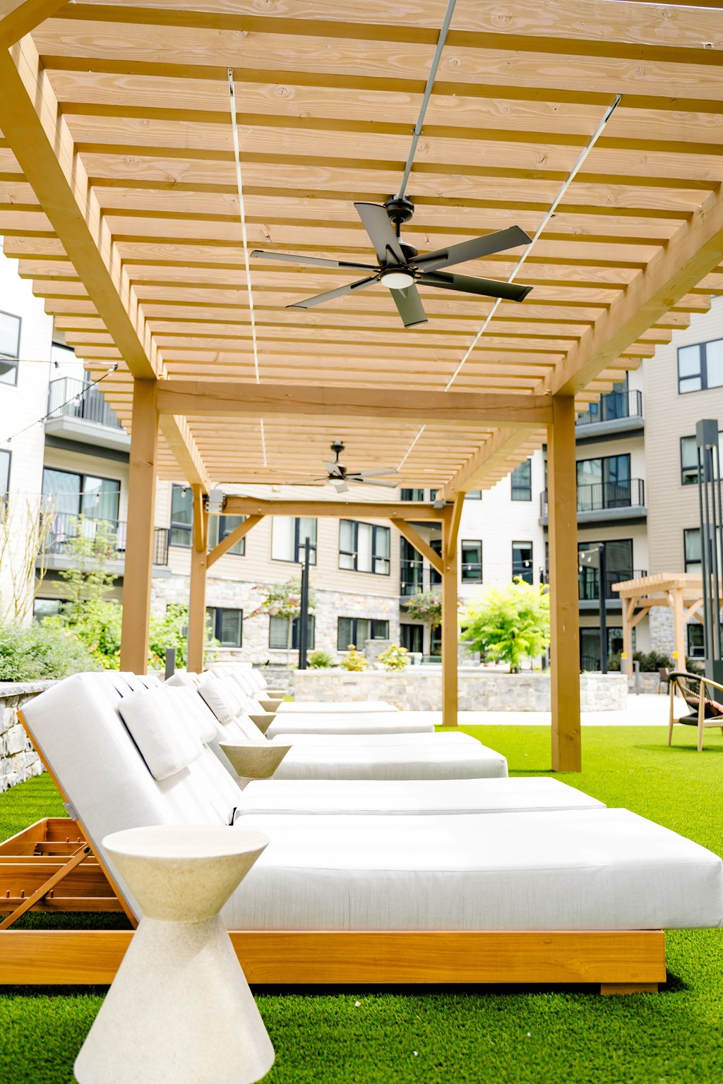 a patio with white couches and a wooden pergola at The Harrison, Newtown Square, 19073