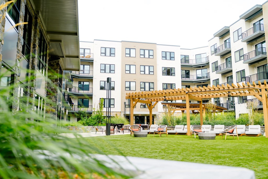 an apartment complex with a patio and a pergola at The Harrison, Newtown Square, PA, 19073