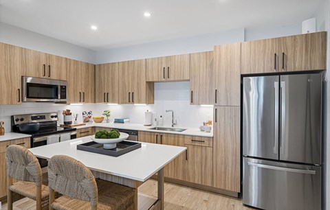 a kitchen with a island and a stainless steel refrigerator