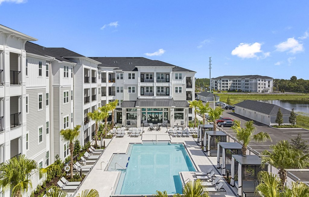 an apartment building with a pool in the middle at Madison Waterford Lakes, Orlando, FL, 32826