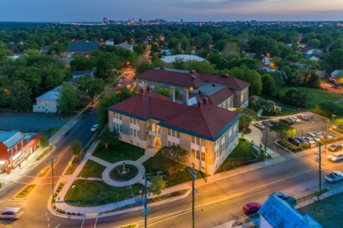 an aerial view of a building on a city street at dusk