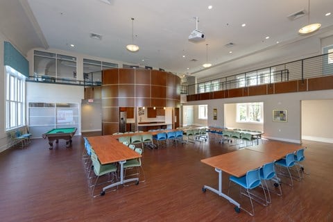 a large room with tables and chairs and a pool table