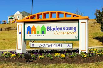 a sign for a bladenburg commons sign in front of a park