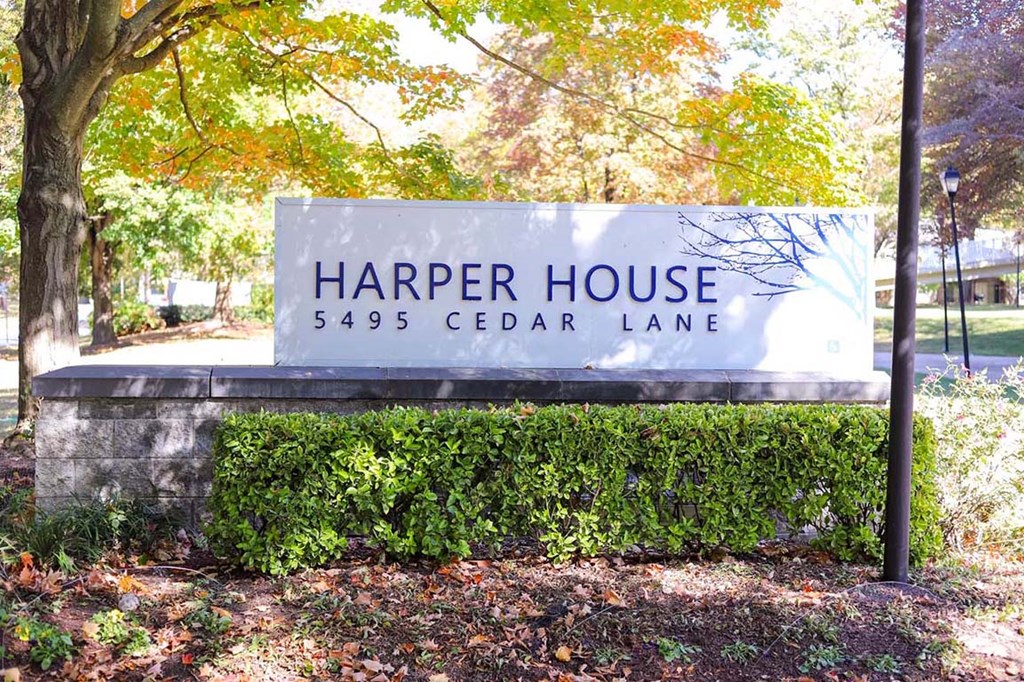 a sign for harper house in front of a tree