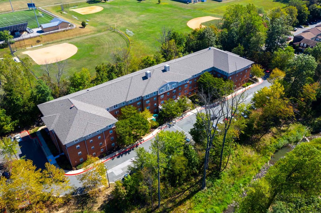 a view of a building from above with a golf course and trees