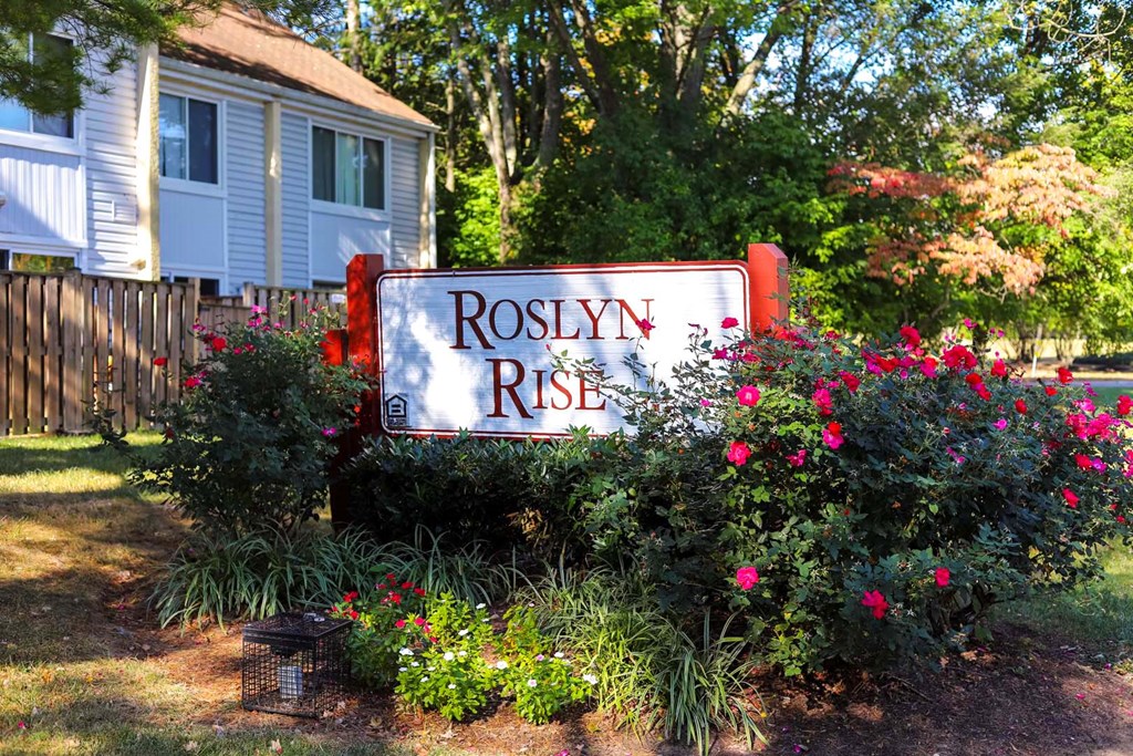 a sign for roselyn rise in front of a house