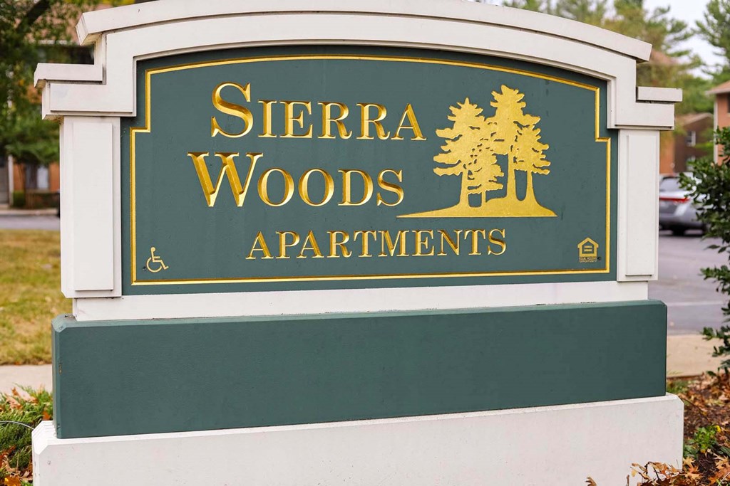 a sign apartments on the side of a street